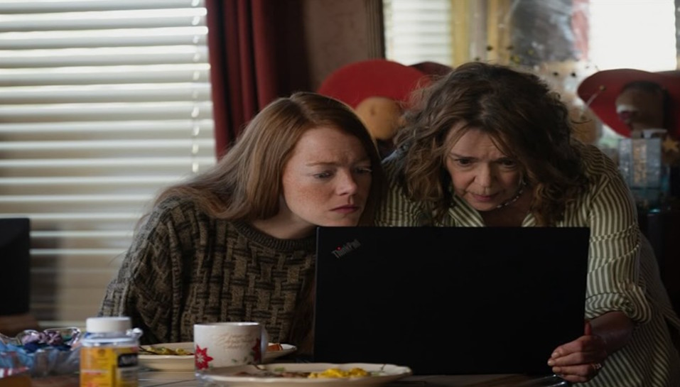 A still depicting two women looking at laptop in Ari Aster's "Eddington," as reviewed by poet Ezekiel Yu.